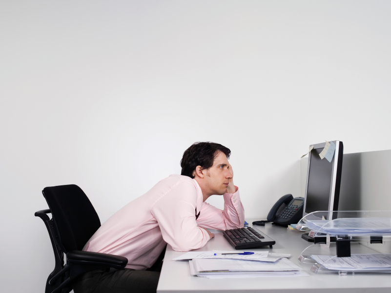 Bored Male Office Worker At Desk - Health Risks faced by office workers in Malaysia